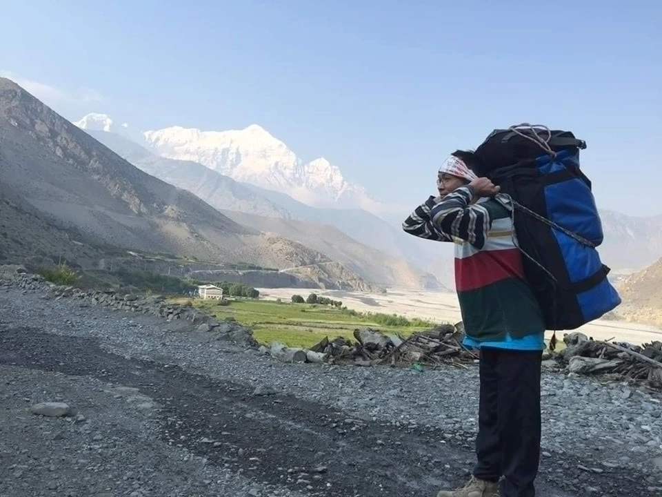 porter carrying bag on the way to muktinath temple